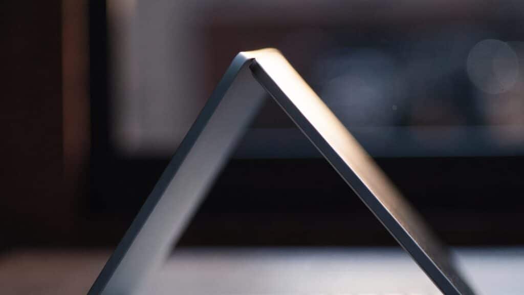 A slim matte grey laptop half open photographed from the side