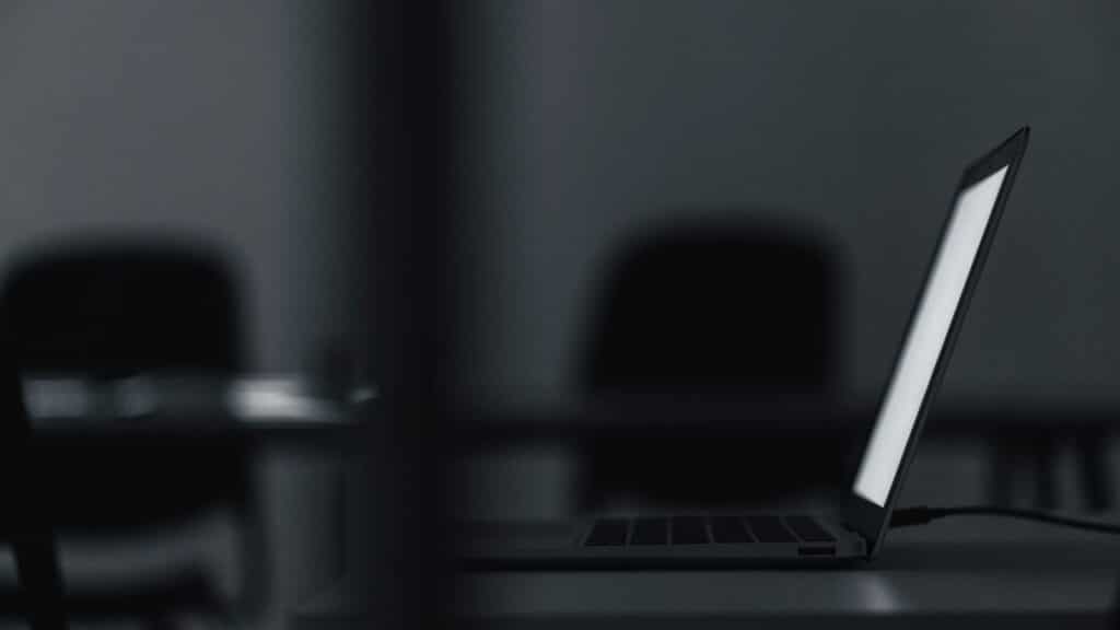 A graphite black laptop in a dark room
