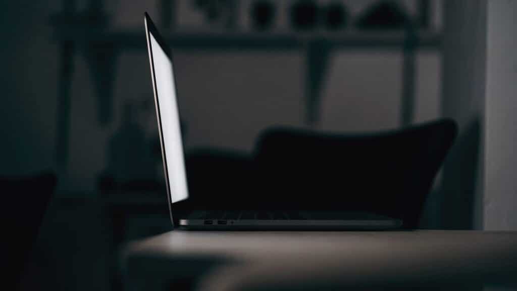 A graphite black laptop in a dark room