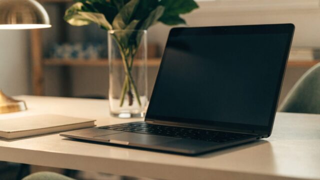 A tidy home office desk with a graphite black laptop
