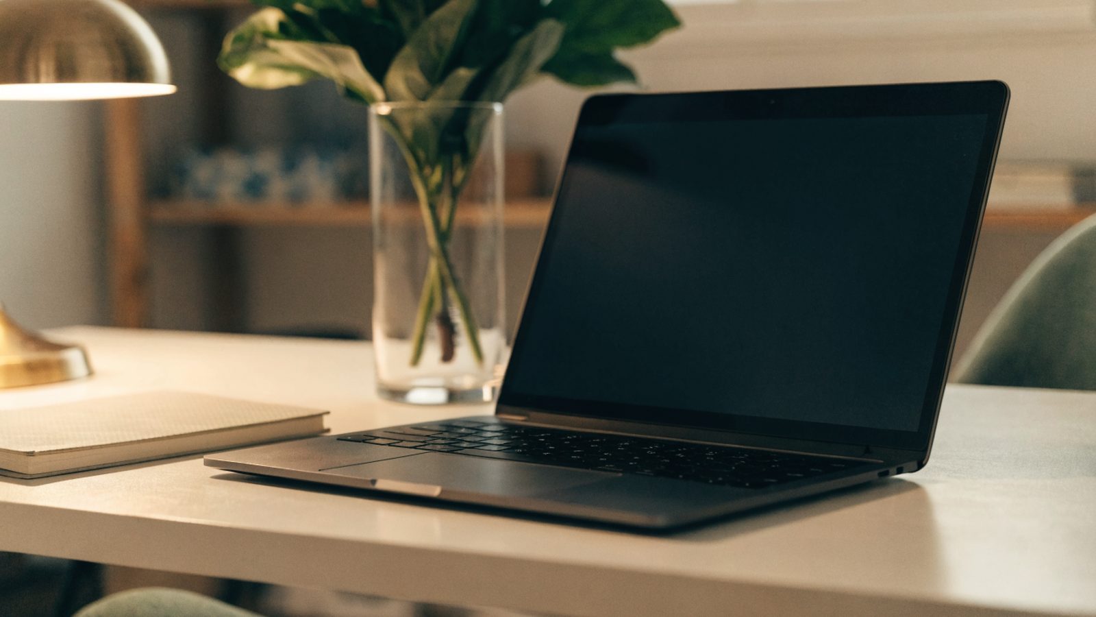 A tidy home office desk with a graphite black laptop