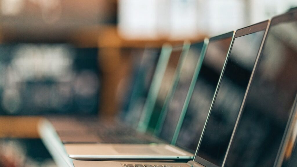 A row of new laptops on display on a store shelf