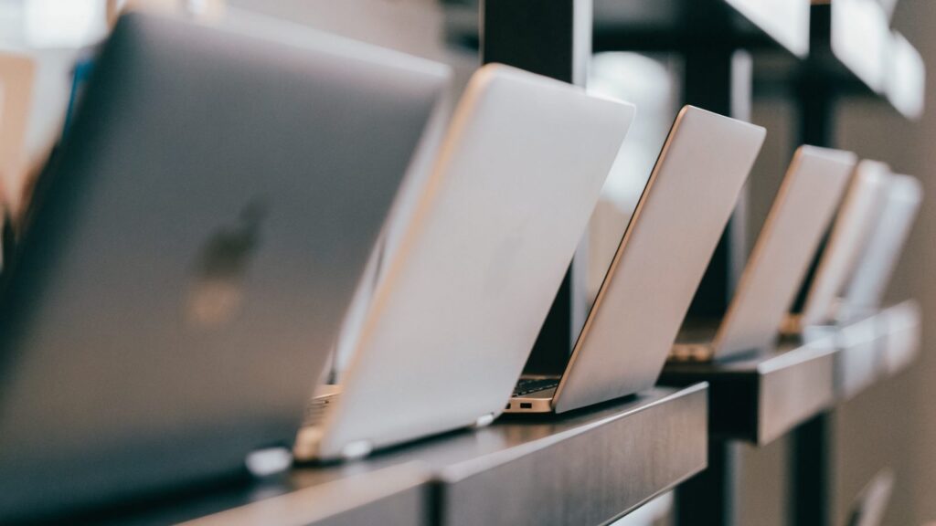 A row of new laptops on display on a store shelf