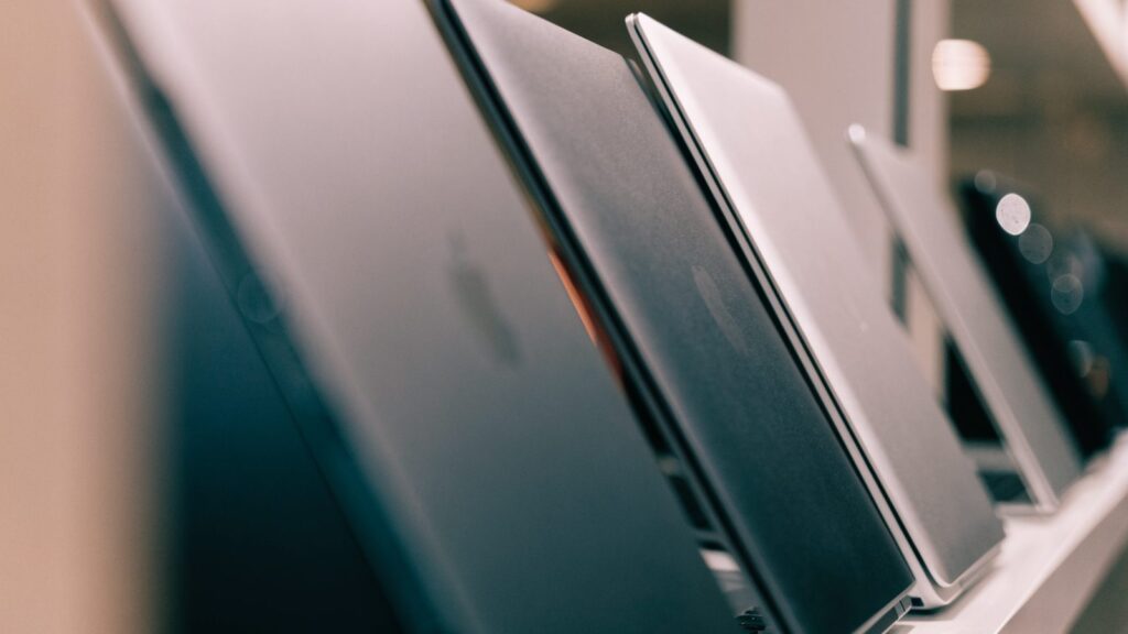 A row of new laptops on display on a store shelf