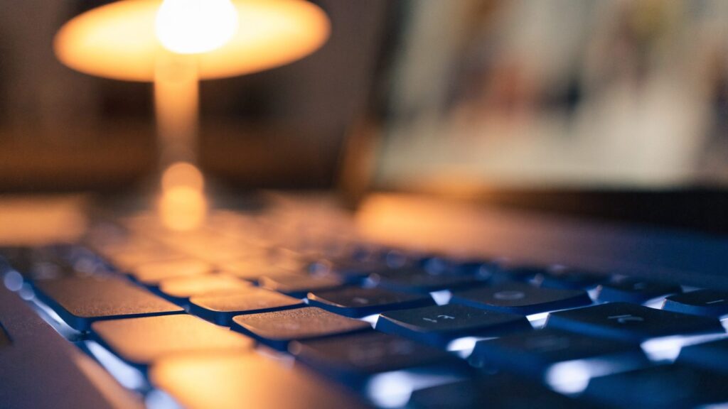 Macro close-up of backlit keys on a dark blue laptop keyboard