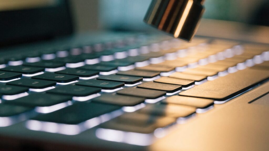 Macro close-up of backlit keys on a matte grey laptop keyboard
