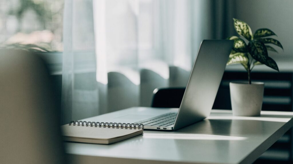 A tidy home office desk with a silver laptop