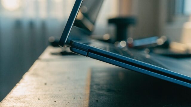 Close-up of the hinge and screen edge of a dark blue laptop on a workbench