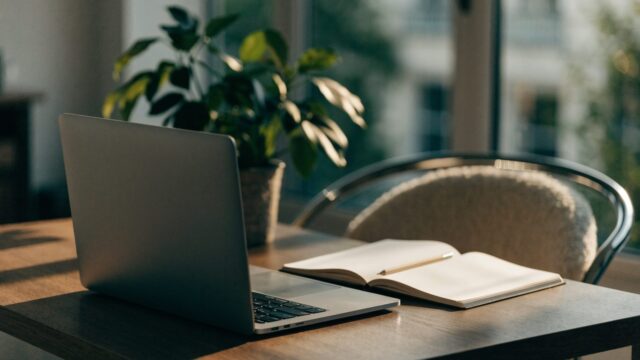 A tidy home office desk with a matte grey laptop