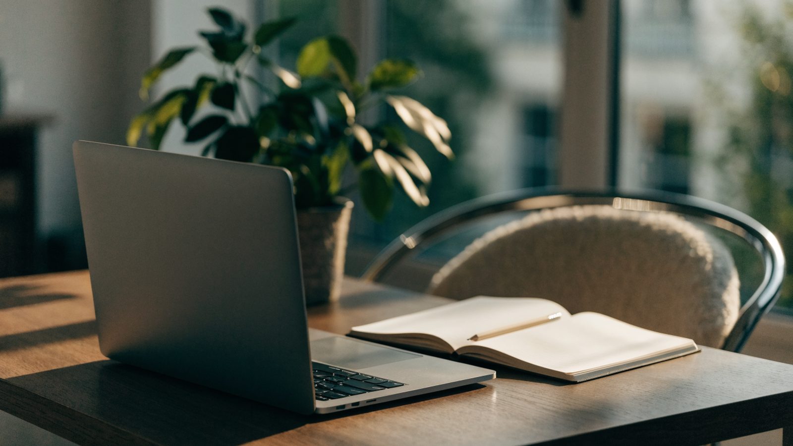 A tidy home office desk with a matte grey laptop
