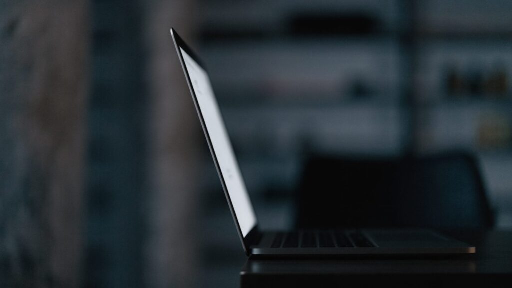 A graphite black laptop in a dark room