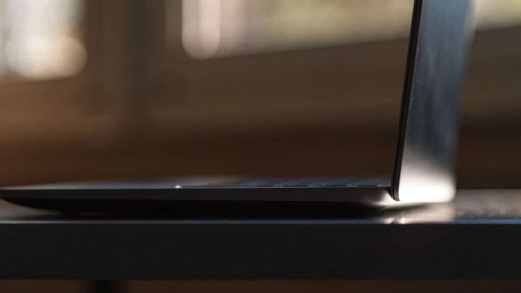 A slim graphite black laptop half open photographed from the side