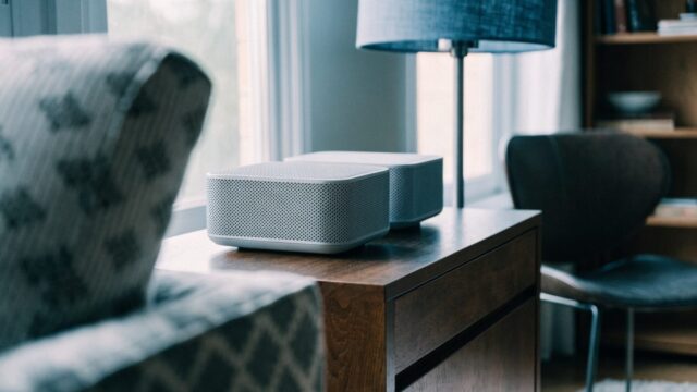 Two mesh wifi units on a sideboard in a cozy living room