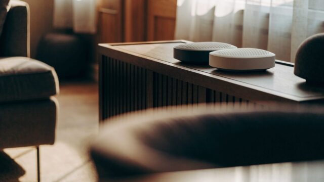 Two mesh wifi units on a sideboard in a cozy living room