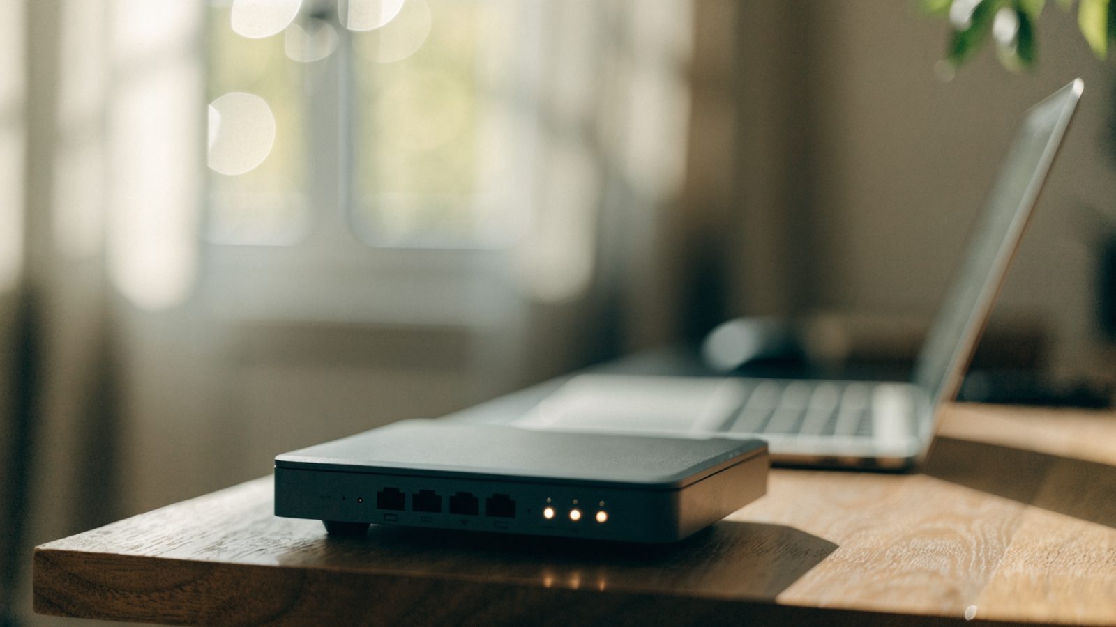A home wifi router with softly glowing indicator lights on a shelf
