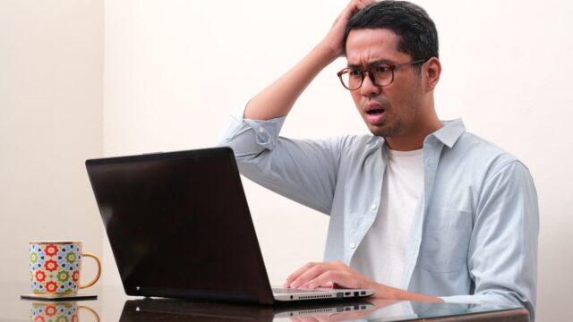 A man showing confused face expression when working using a laptop