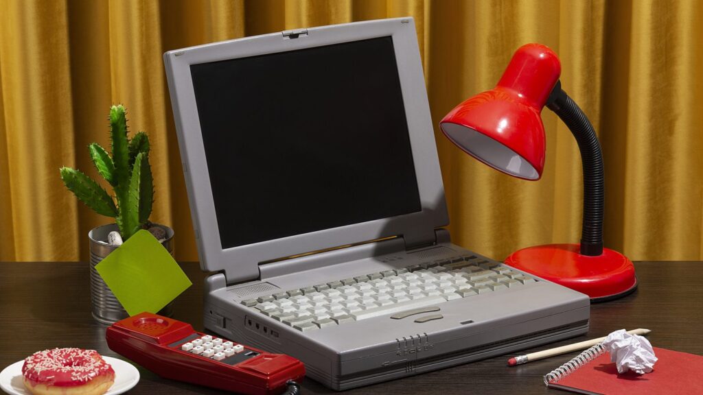 Messy office desk with old computer still life