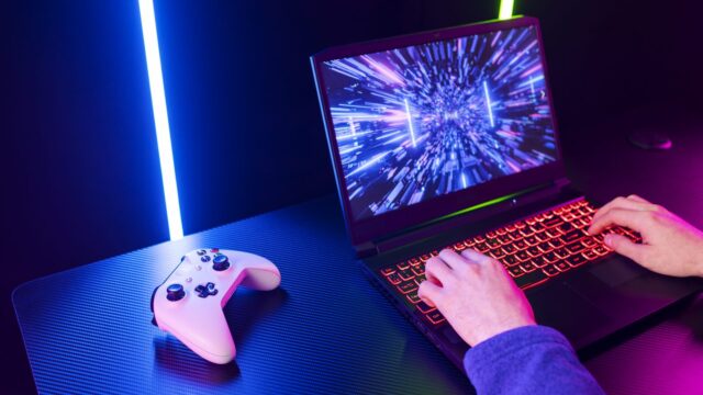 High angle gamer playing on laptop