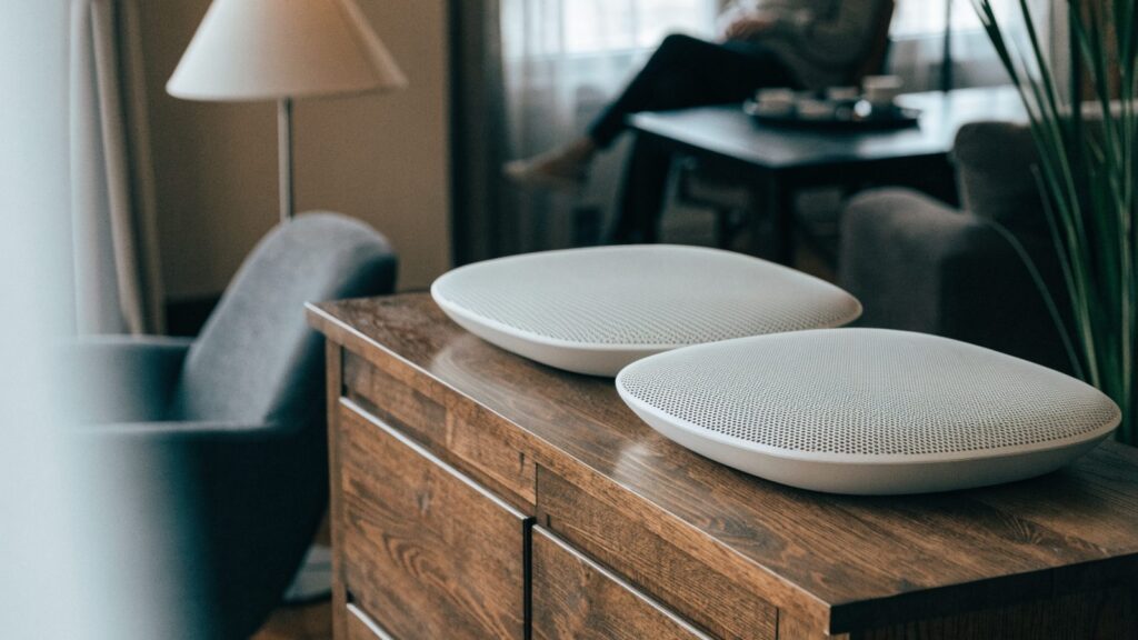 Two mesh wifi units on a sideboard in a cozy living room