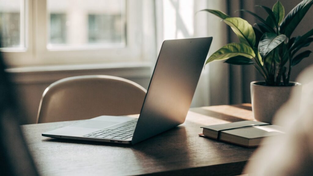 A tidy home office desk with a matte grey laptop
