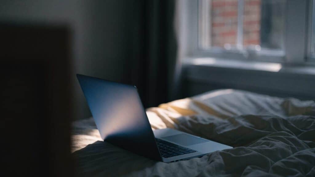 A dark blue laptop in a dark room