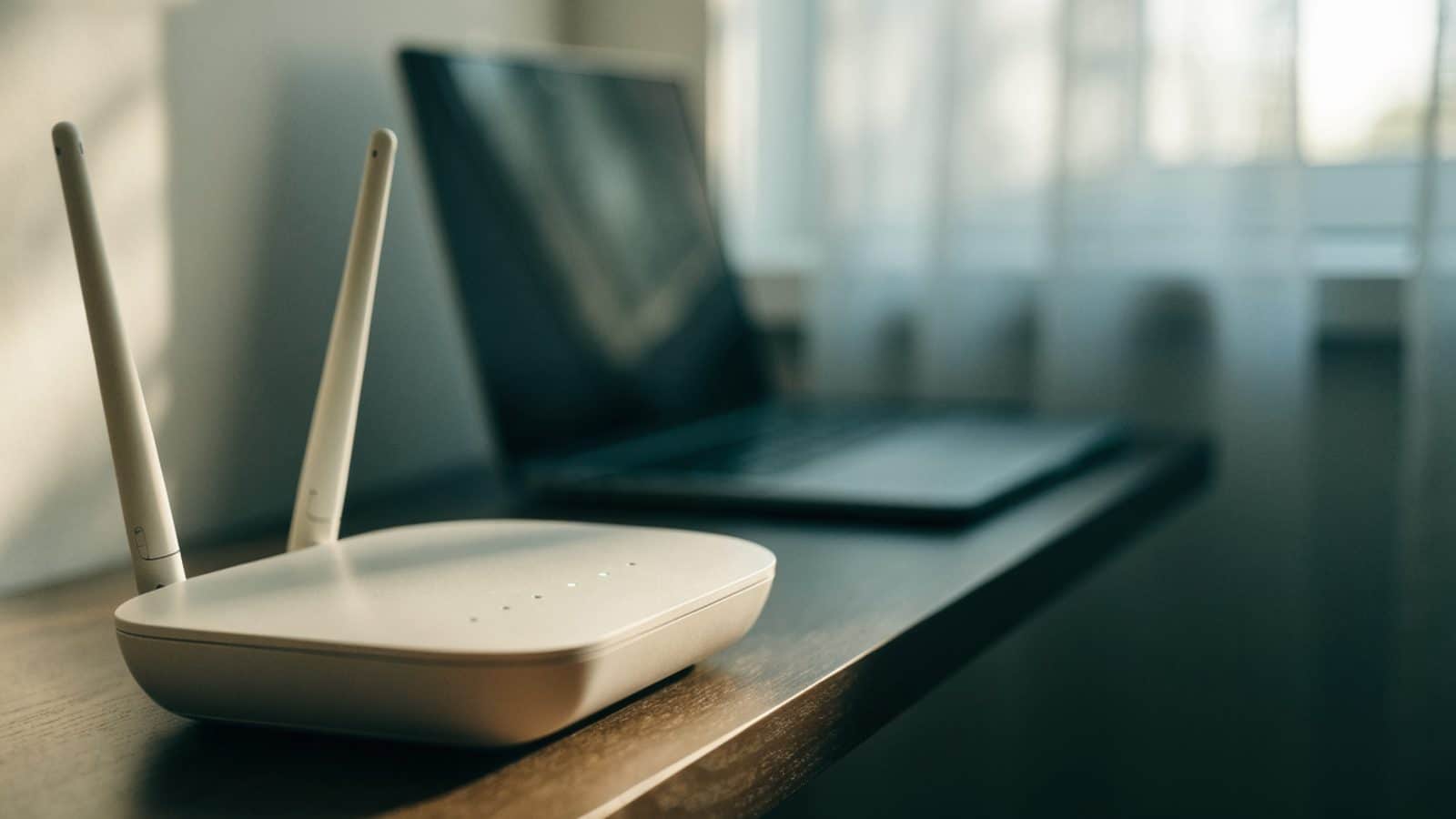 A home wifi router with softly glowing indicator lights on a shelf