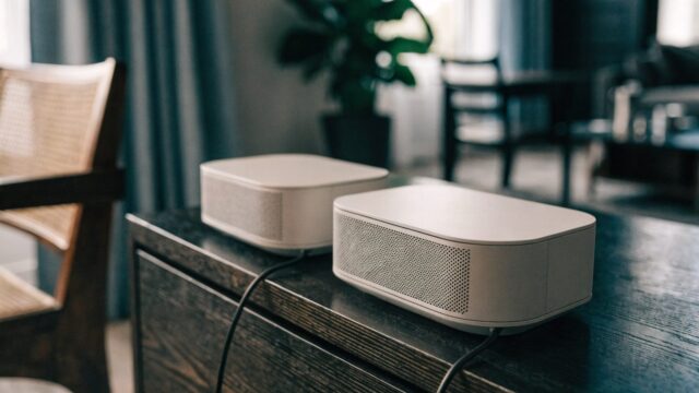 Two mesh wifi units on a sideboard in a cozy living room