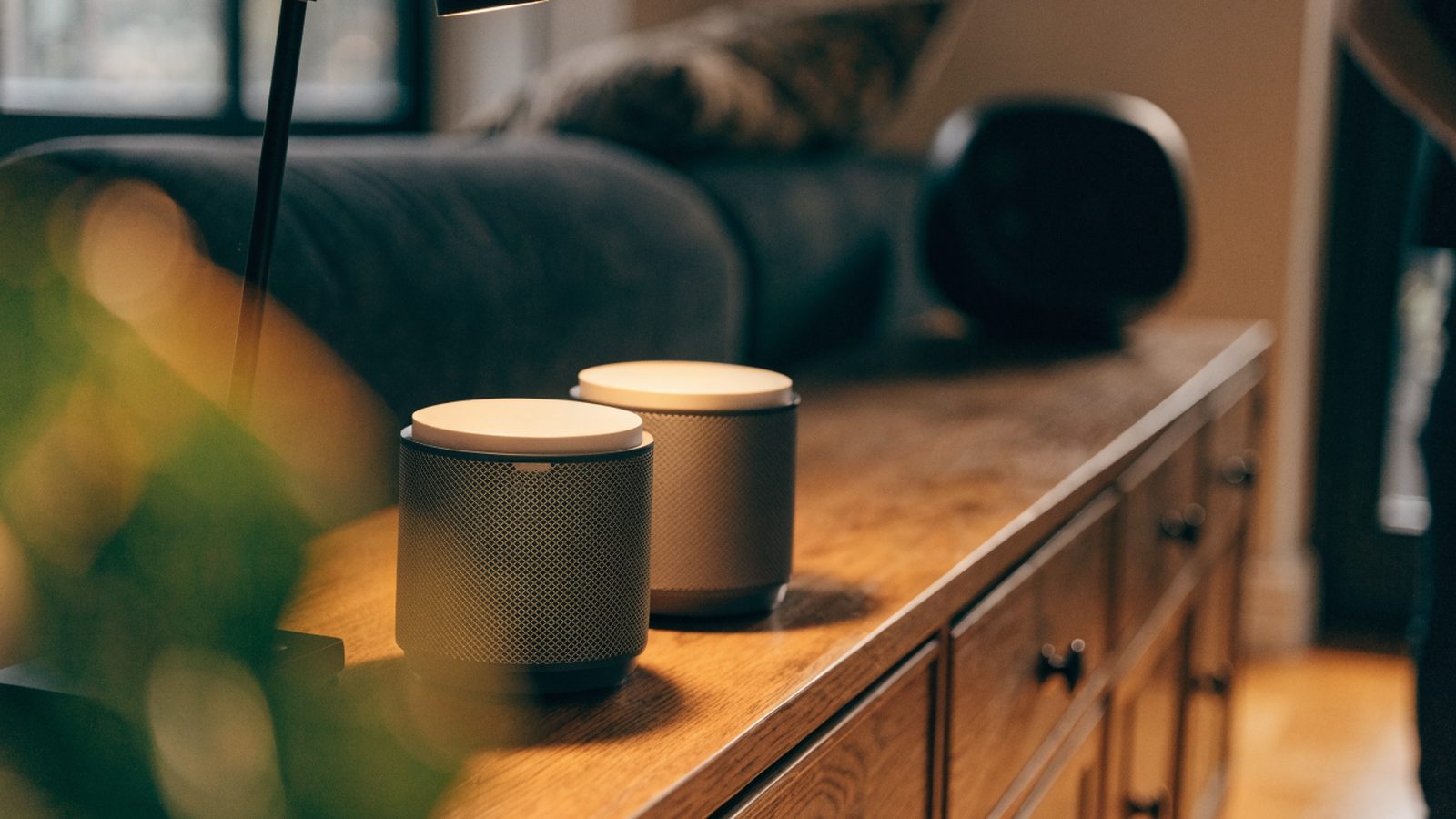 Two mesh wifi units on a sideboard in a cozy living room