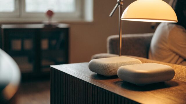 Two mesh wifi units on a sideboard in a cozy living room