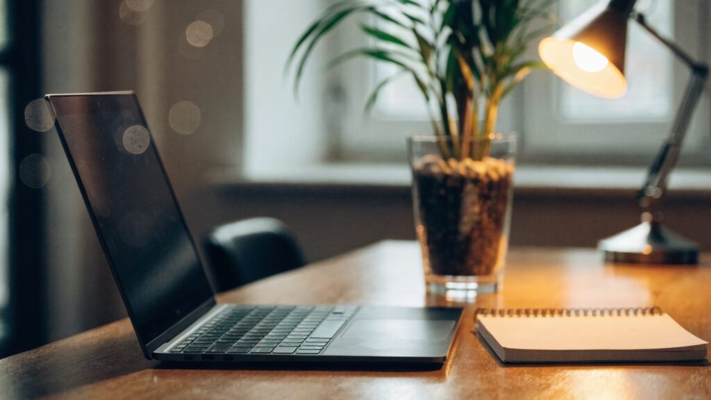 A tidy home office desk with a graphite black laptop