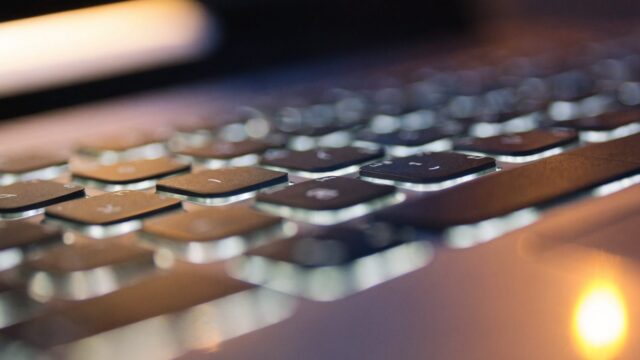 Macro close-up of backlit keys on a silver laptop keyboard