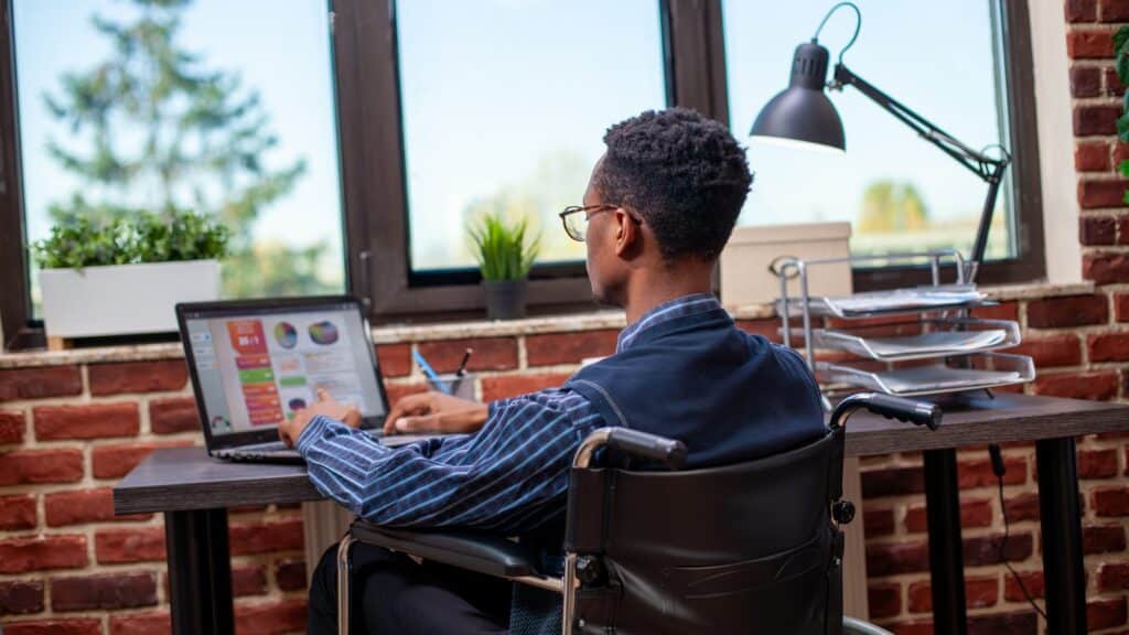 Male wheelchair user working in office