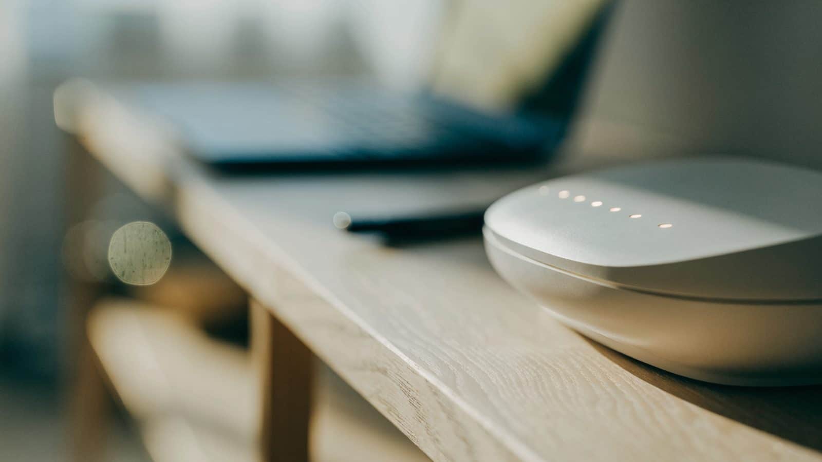A home wifi router with softly glowing indicator lights on a shelf