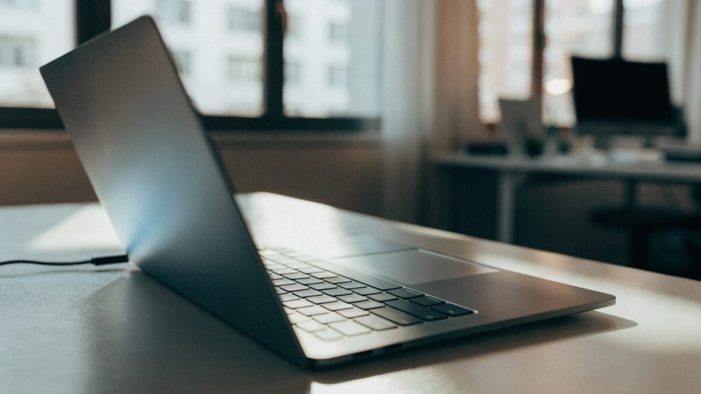 A matte grey laptop half closed on an office desk