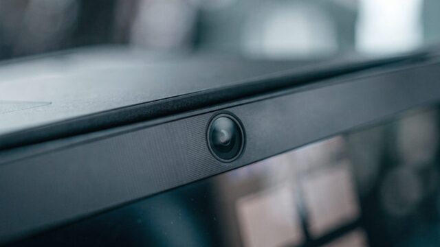 Macro close-up of the webcam above the screen of a graphite black laptop