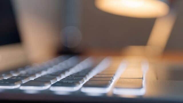 Macro close-up of backlit keys on a matte grey laptop keyboard