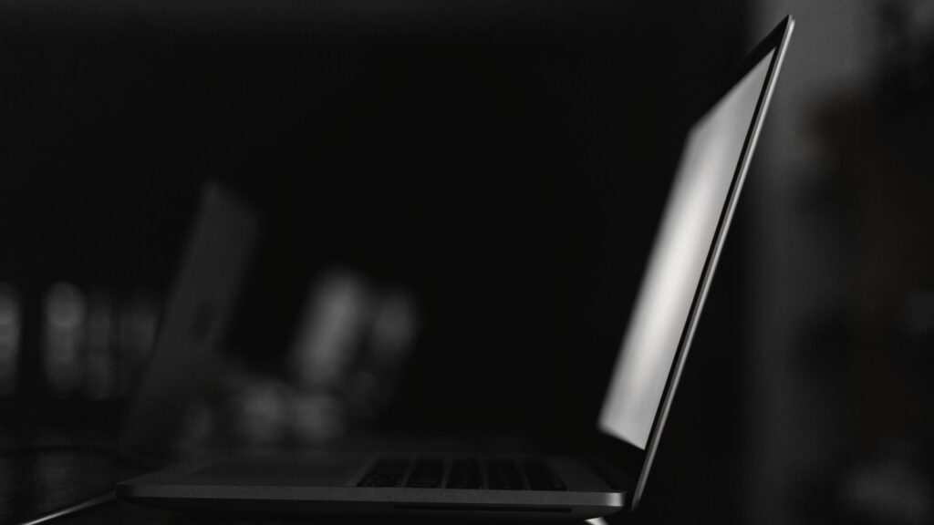 A matte grey laptop in a dark room