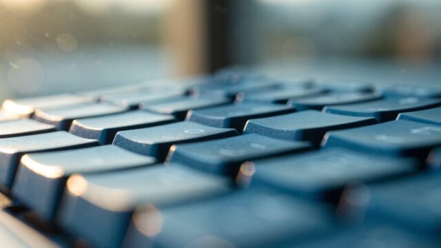 Macro close-up of backlit keys on a dark blue laptop keyboard