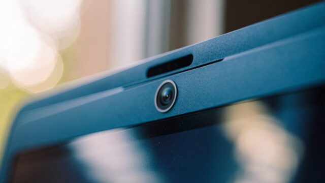 Macro close-up of the webcam above the screen of a dark blue laptop