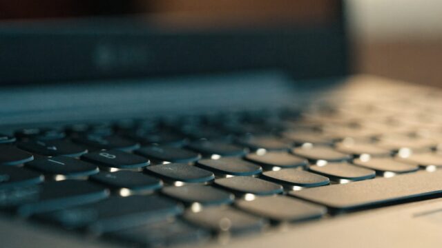 Macro close-up of backlit keys on a graphite black laptop keyboard