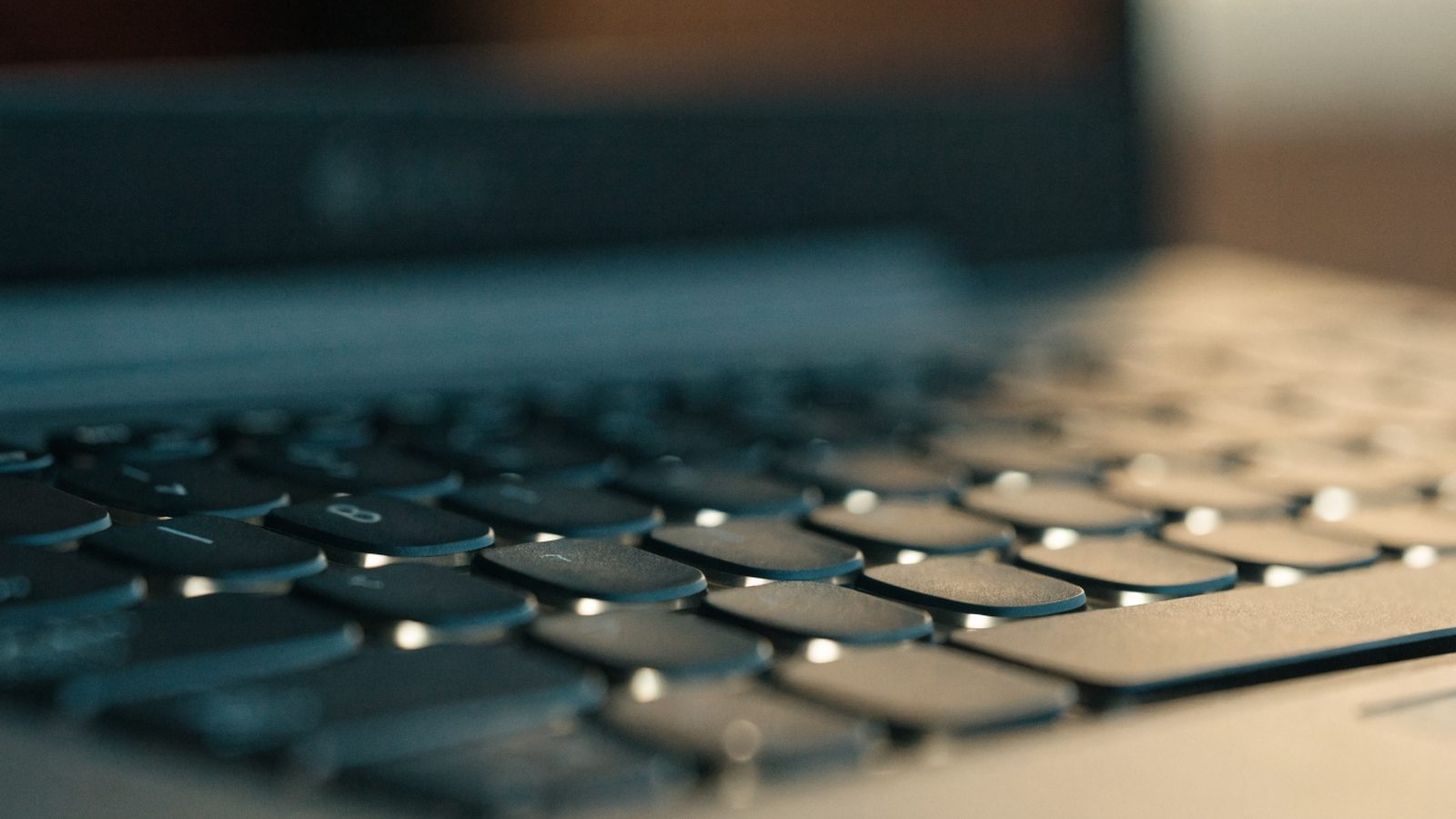 Macro close-up of backlit keys on a graphite black laptop keyboard