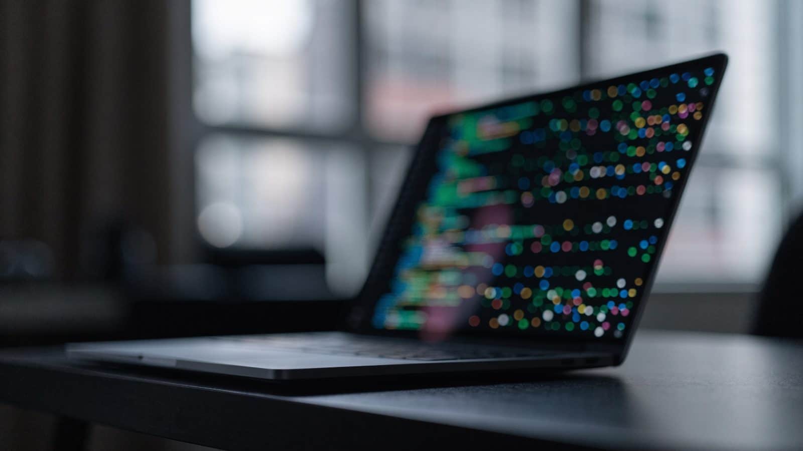 A matte grey laptop in a dim room