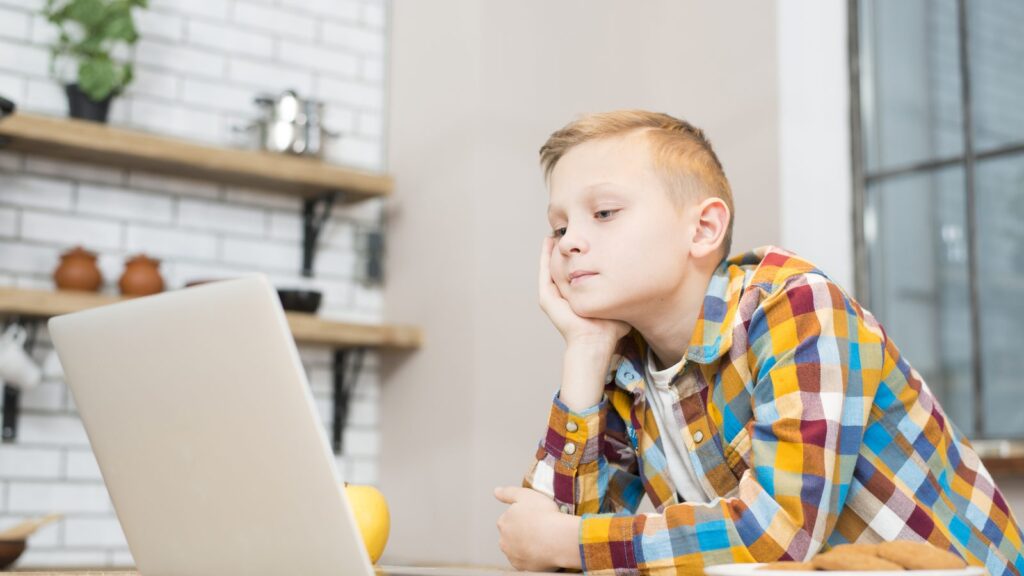 Boy with laptop in kitchen