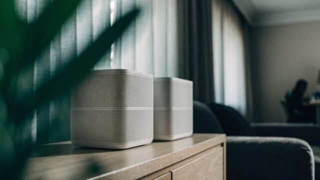 Two mesh wifi units on a sideboard in a cozy living room