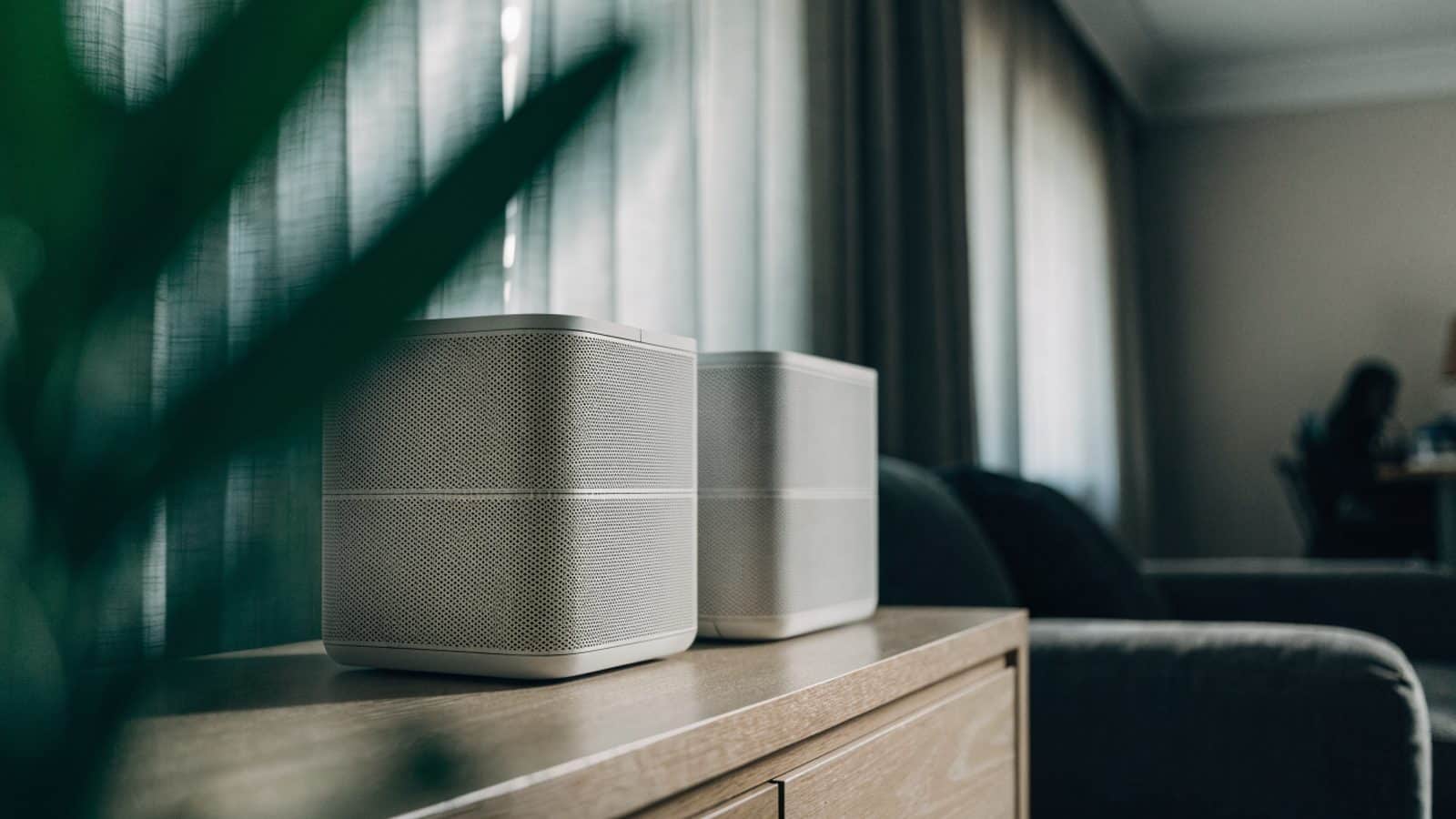 Two mesh wifi units on a sideboard in a cozy living room