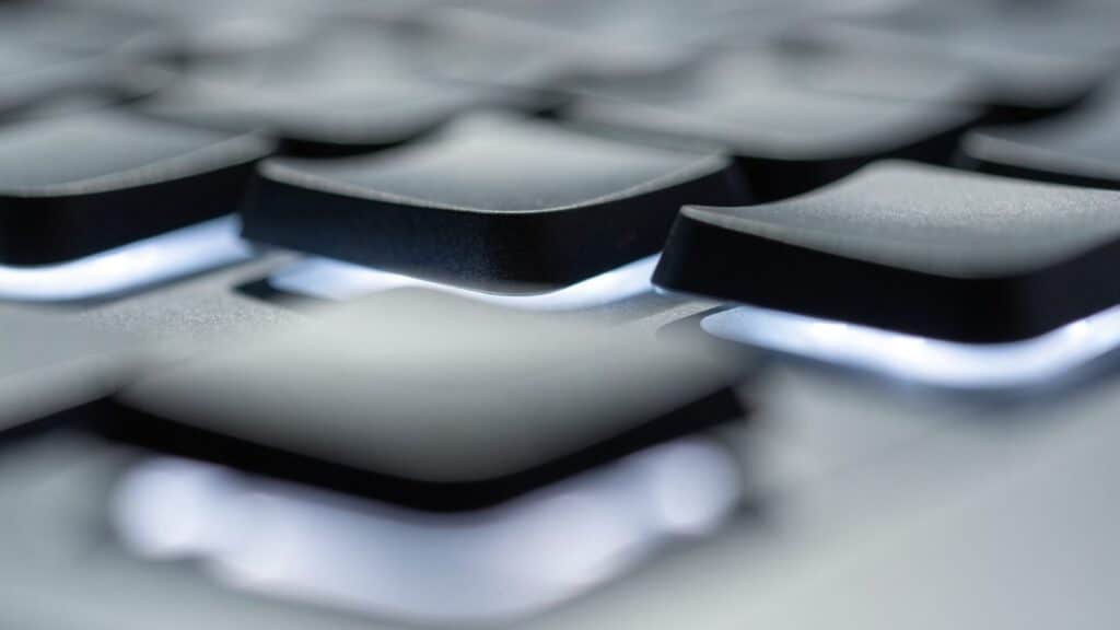 Macro close-up of backlit keys on a matte grey laptop keyboard