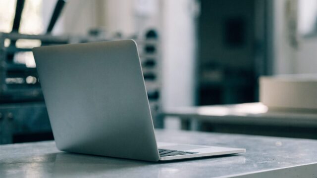 A silver laptop on a workbench with a completely dark blank screen